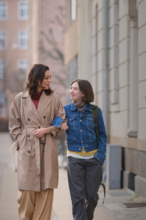 Mother and daughter walking arm in arm.